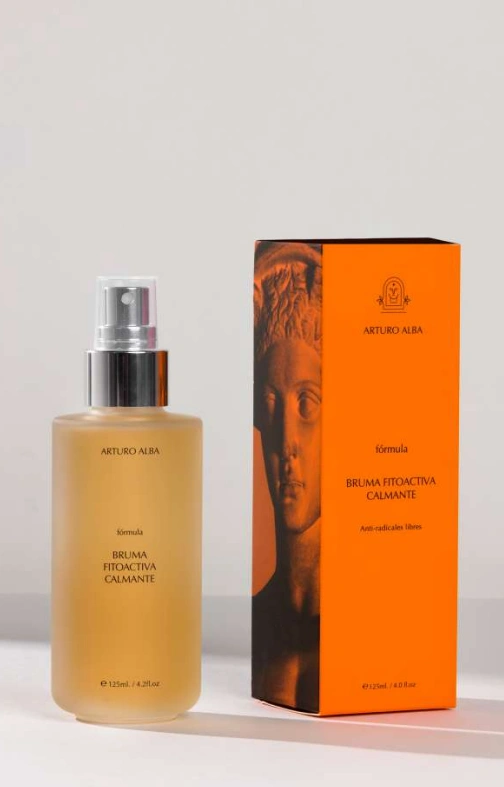 Frasco de la Bruma Fitoactiva Calmante de Arturo Alba junto a su estuche naranja, formato de 125 ml