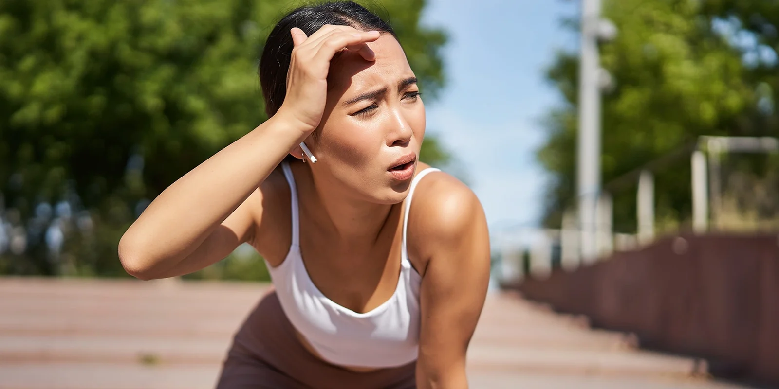 Esportista eixugant-se la suor durant un entrenament a l'aire lliure en un dia de calor